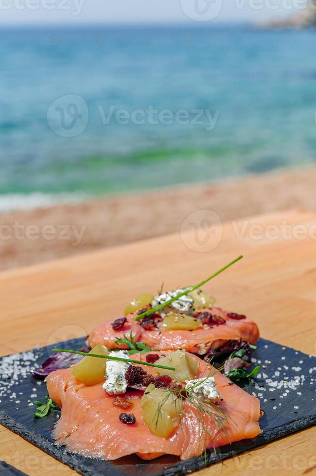 ahumado salmón plato, en un de madera mesa foto