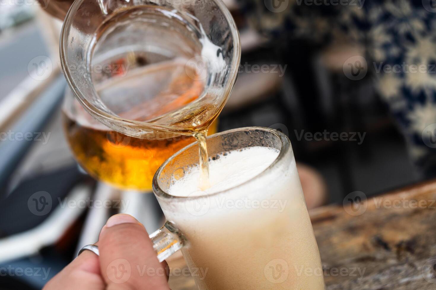 Fresh beer is poured into a glass photo