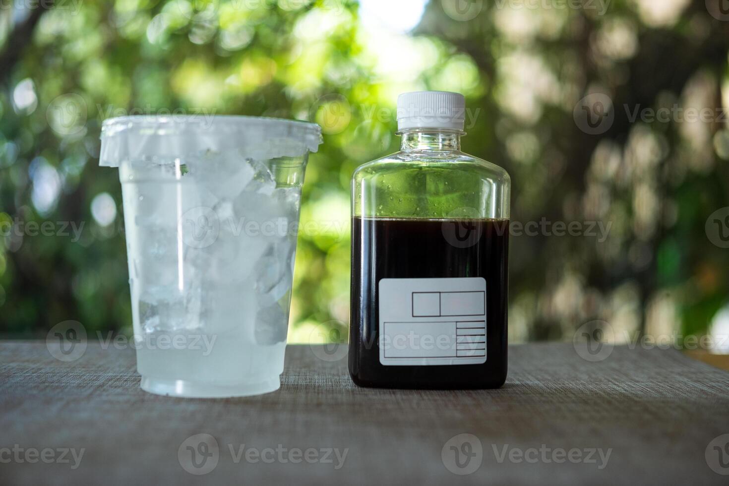 Cold brew coffee in a glass bottle and ice in glass for take away photo