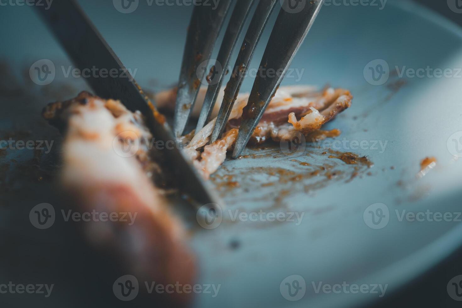 Korean fried chicken wings in a tangy sauce eating with fork and knife photo