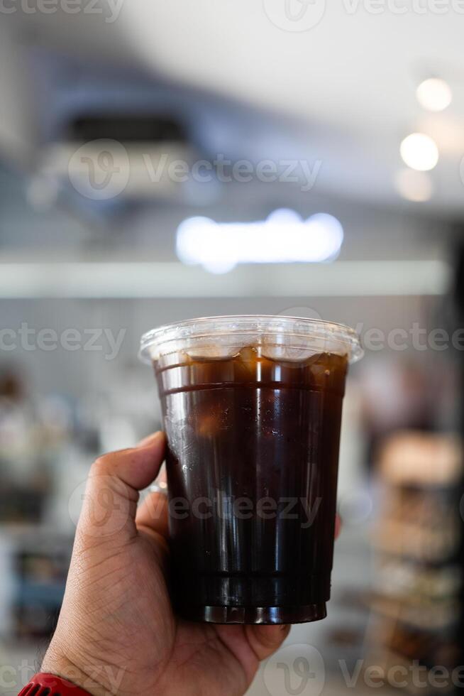Hand hold a glass of iced americano photo