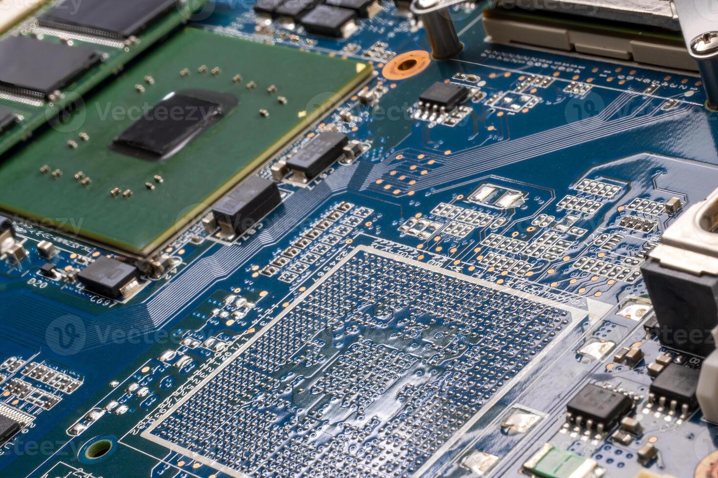 Tight close up of a bluegreen sheen of laptop motherboard with chipsets on it photo