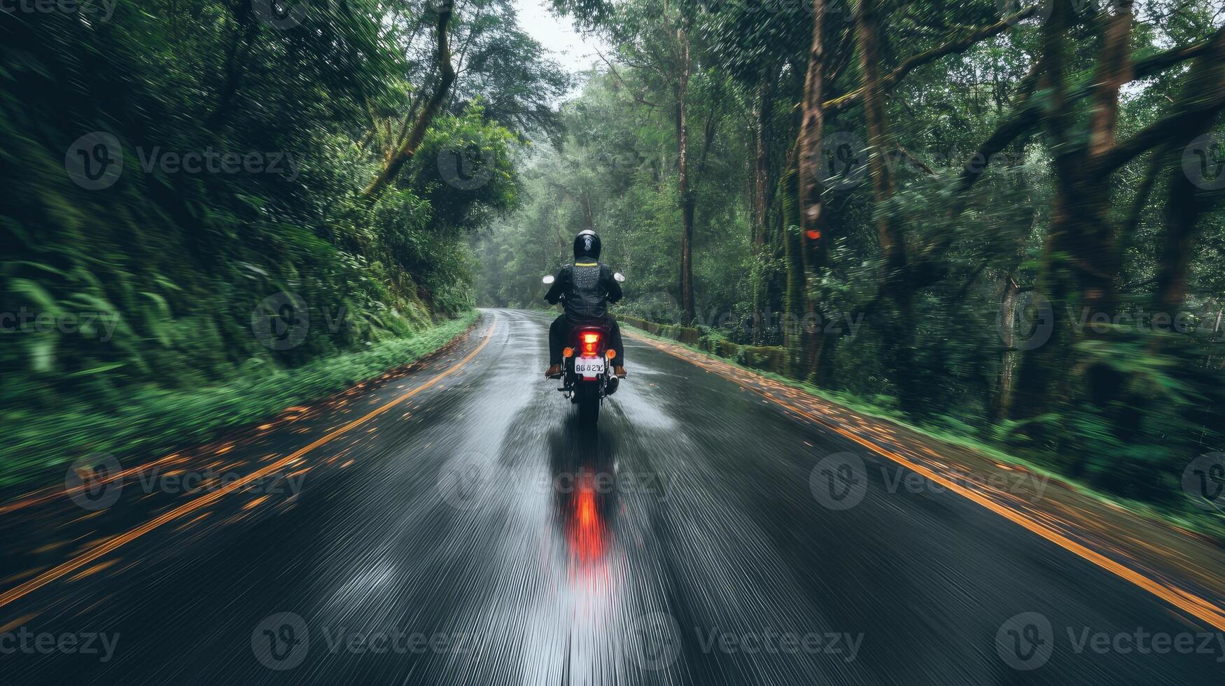 AI generated a motorbike driver navigating through the rain on a densely tree-lined road, the shimmering raindrops and lush foliage creating a captivating ambiance of nature's embrace photo