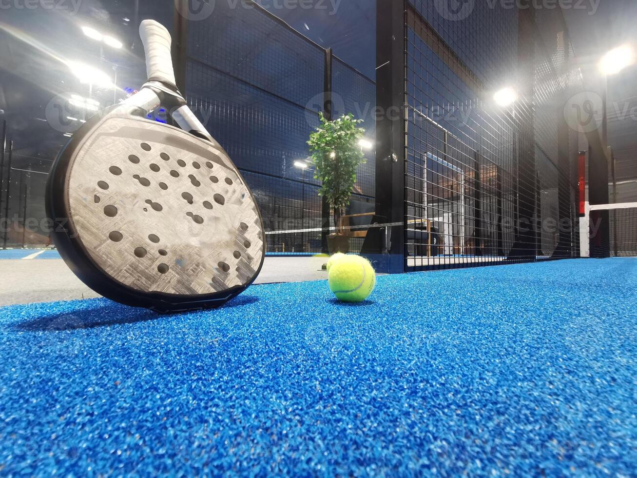 Paddle tennis racket, ball and net on the court photo