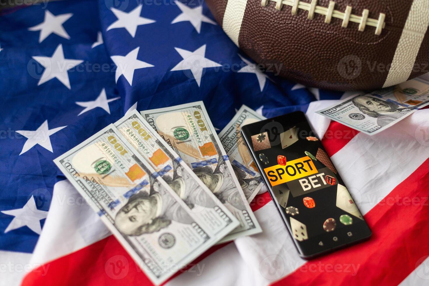 Online sports betting. Dollars are falling on the background of a hand with a smartphone and a soccer ball. Creative background, gambling photo