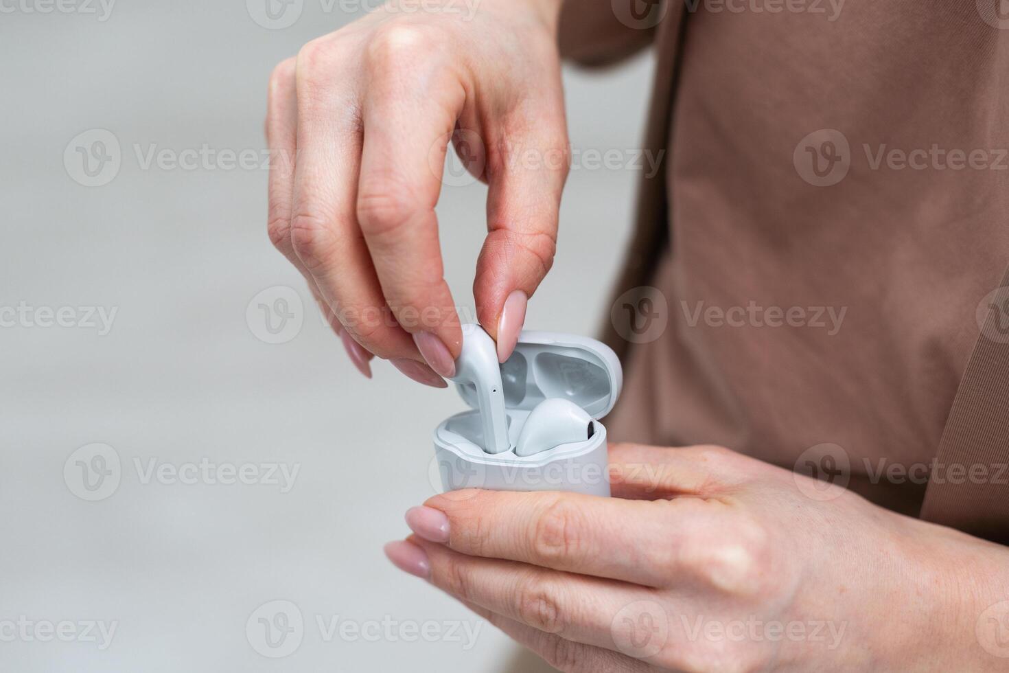 Hand holding Grey wireless headphones isolated on a white background. photo