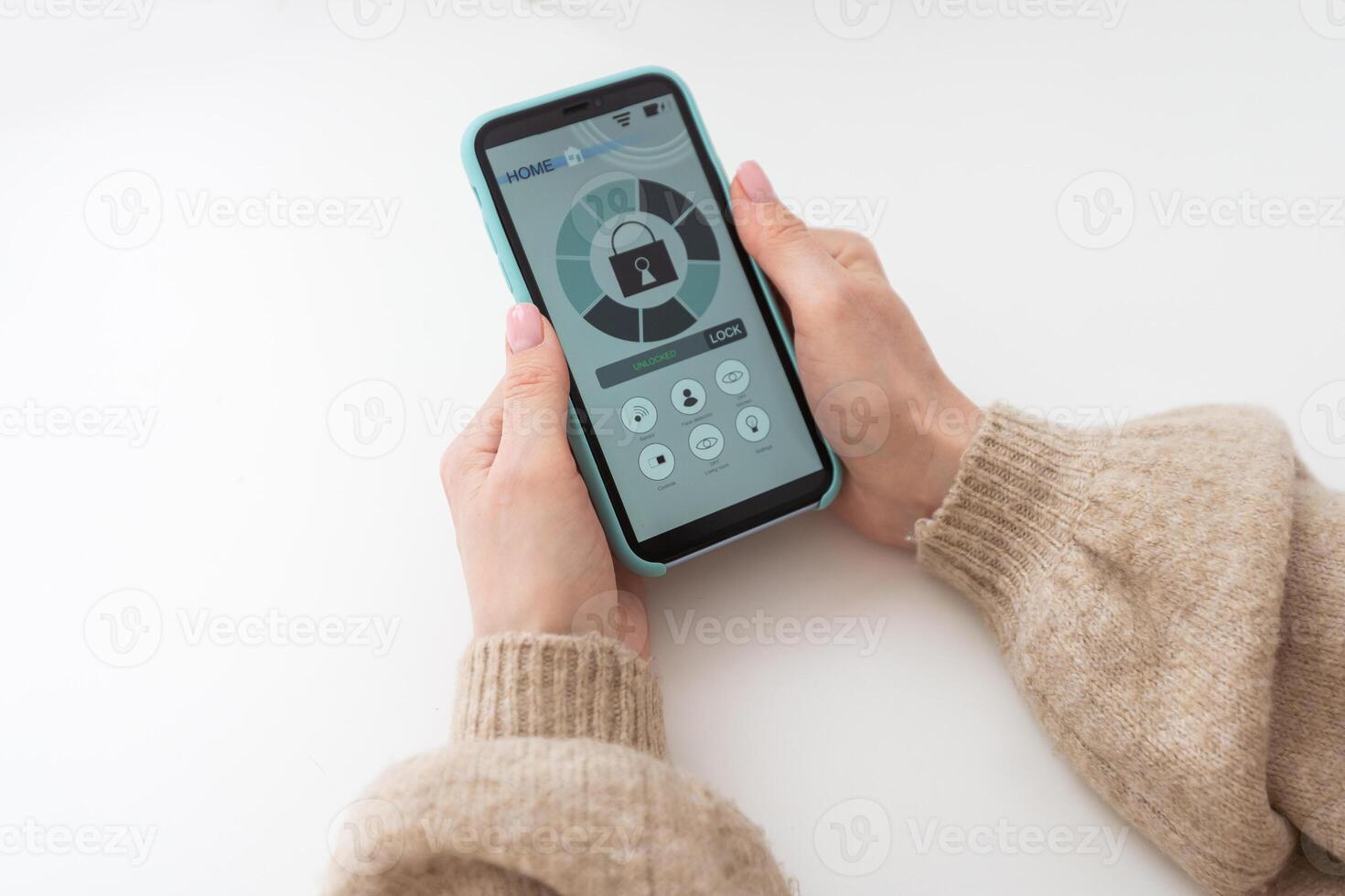 Young woman holding smart phone with launched security application at home. Concept of controlling and managing home security from a mobile device. photo