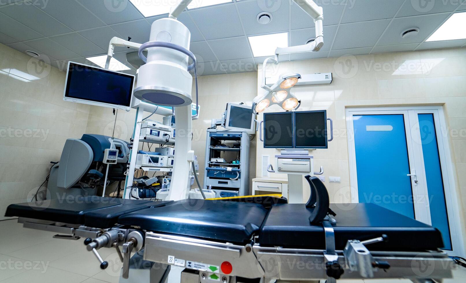 Establishing shot of technologically advanced operating room with no people, ready for surgery. Operating theater with working equipment, lights and computers ready for surgeons. photo