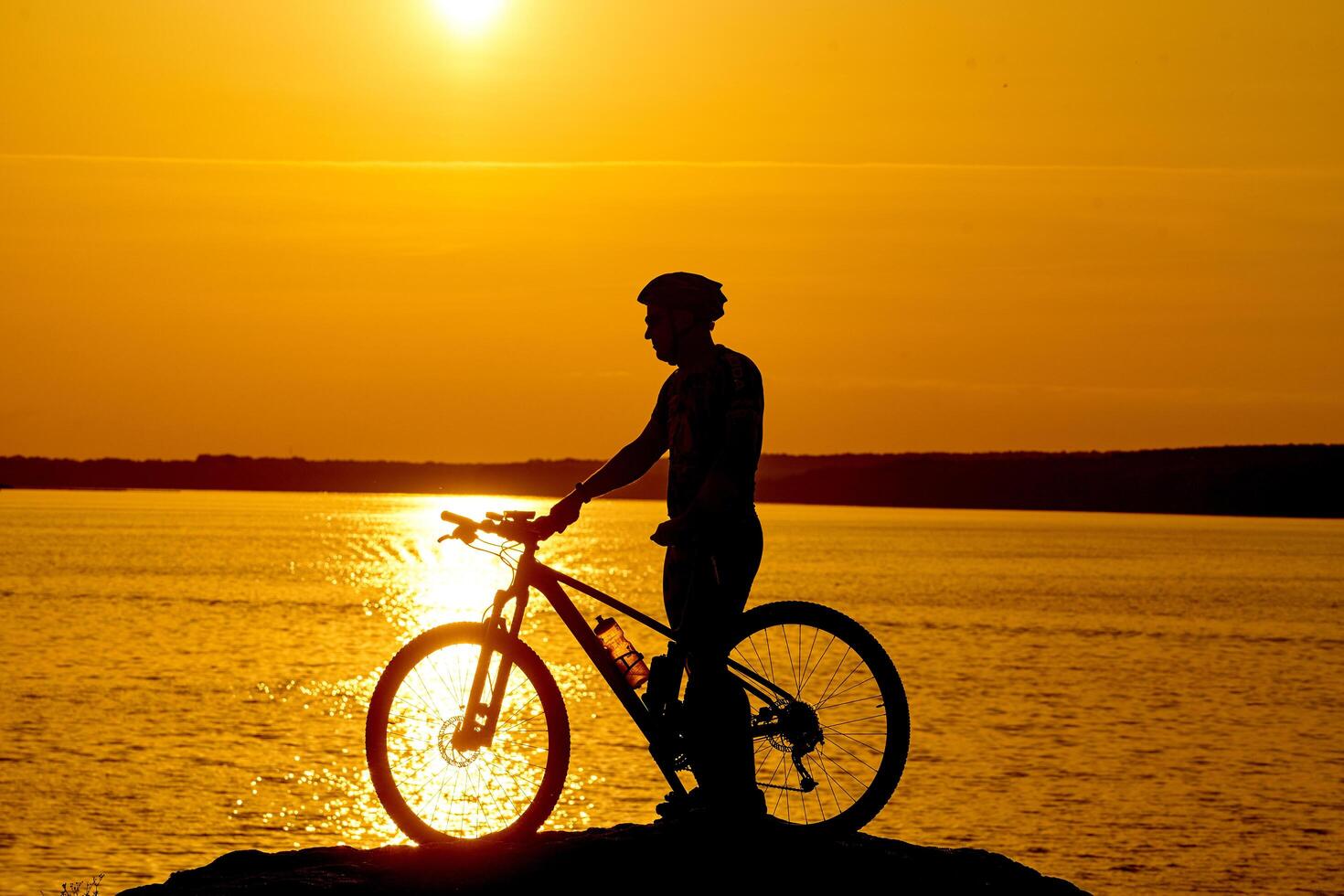 Silhouette of a bike on sky background on sunset on a mountain top. photo