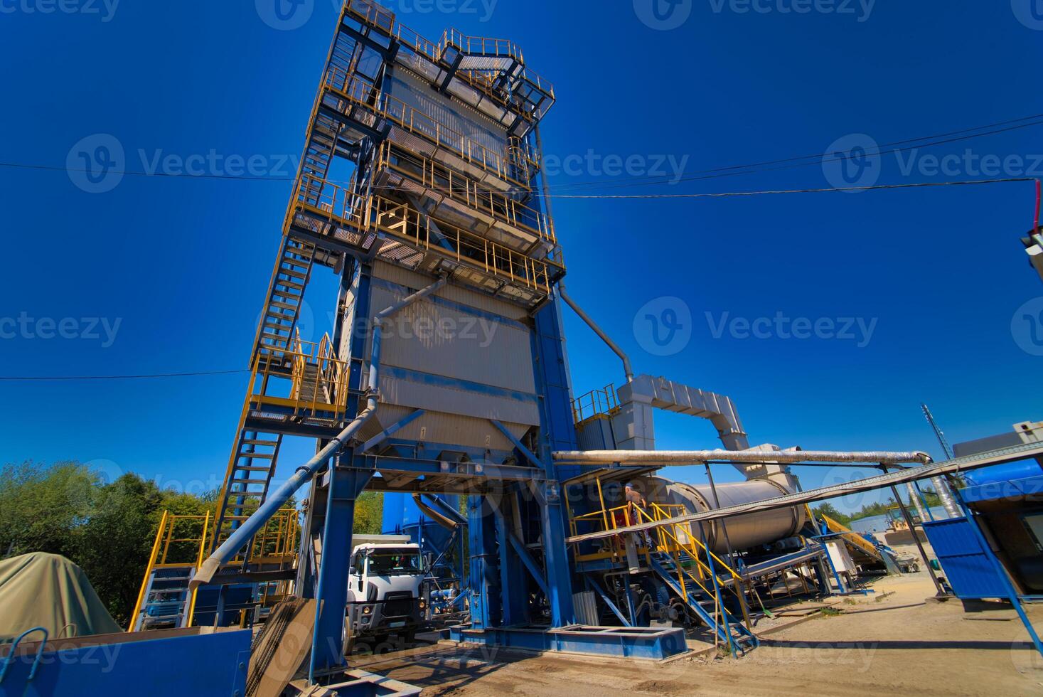 Factory for asphalt production on blue sky background. Selective focus. photo
