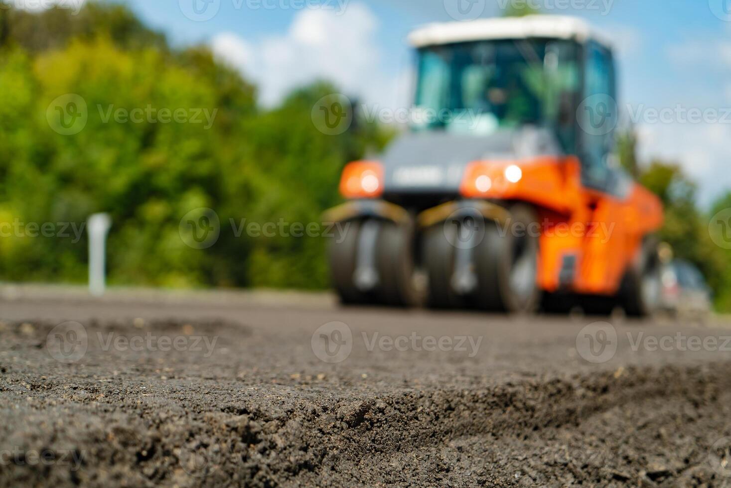roller smooths evenly new asphalt on the road. Close-up photo