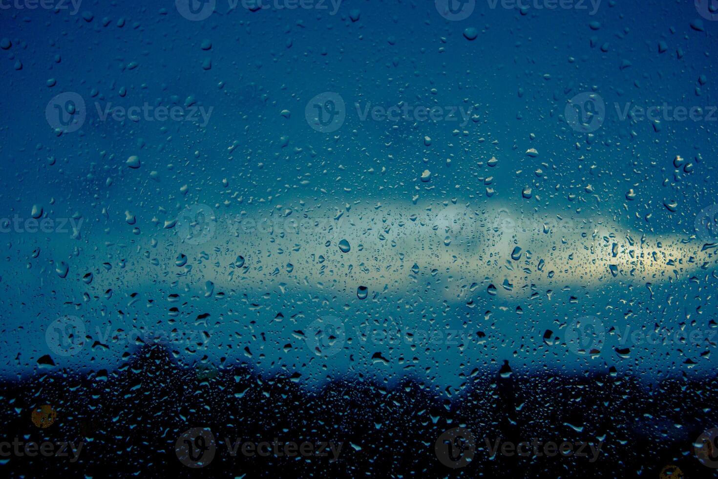 Close-up of drops on window. Background of moving rain drops on a window glass in a rainy day. photo