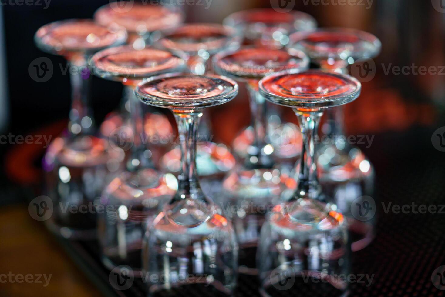 two rows of wine glasses stand upside down on the bar at the cafe. Close-up photo