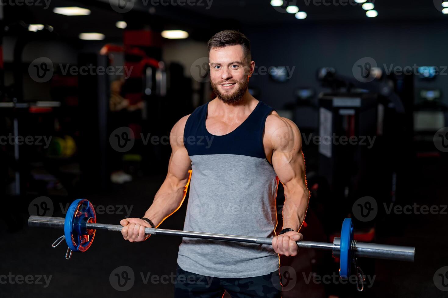 juguetón hombre haciendo levantamiento de pesas en moderno gimnasia. muscular cuerpo tipo. foto