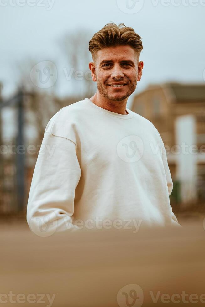 an attractive young man with a white sweater photo