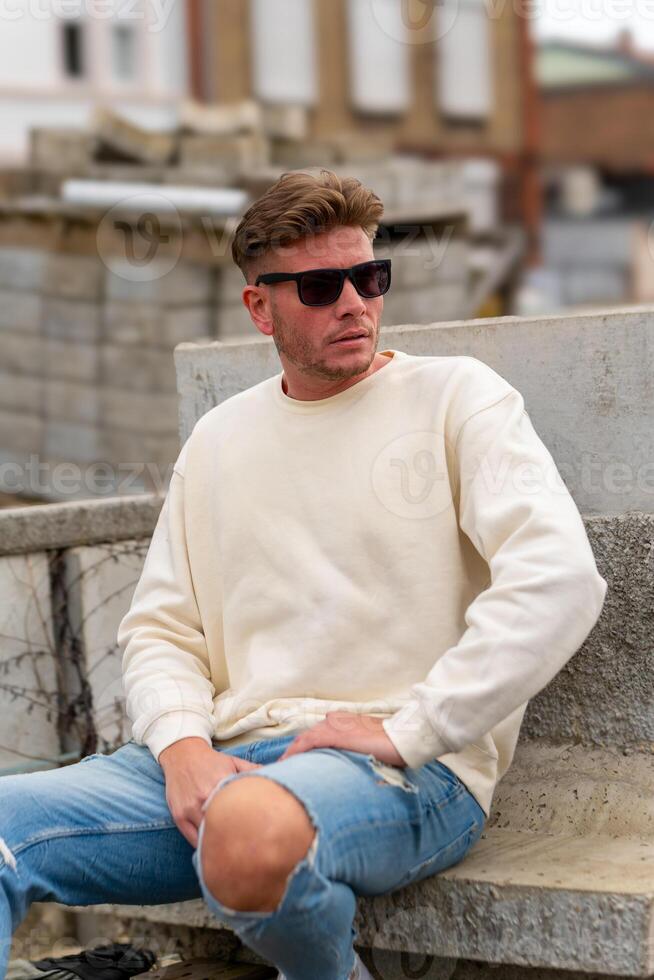 un atractivo joven hombre con un blanco camisa y Gafas de sol foto