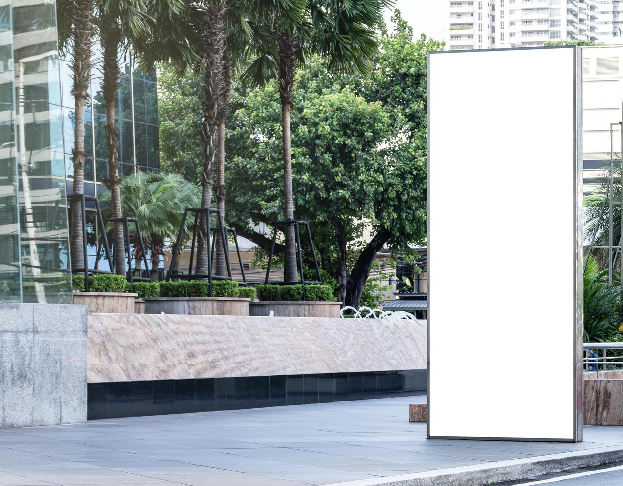 Outdoor vertical light box billboard on footpath with mock up white screen. Clipping path for mockup photo