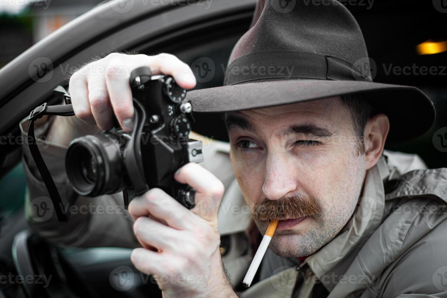 Detective smoking a cigarette in his car while spying someone with his camera photo