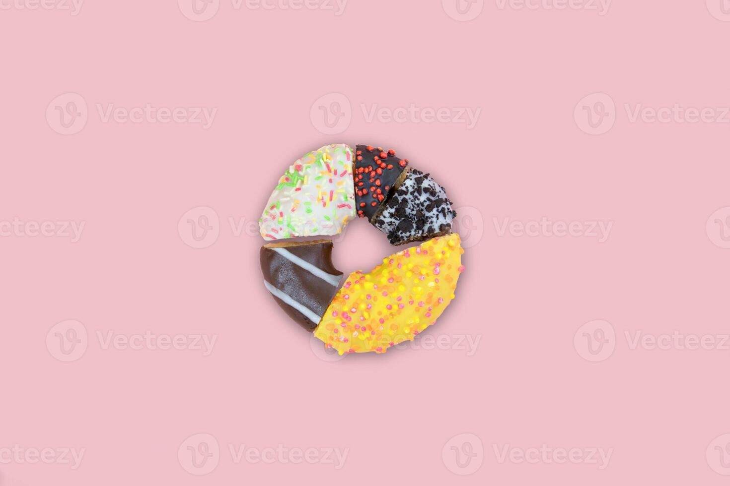 A donut divided into different segments on a pink background,top view photo