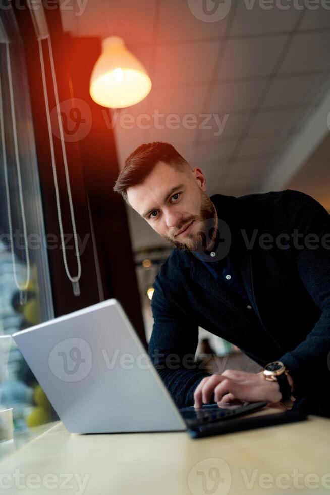 Young man working on notebook. Promising businessman watching new project. Beautiful man working on quarantine. photo