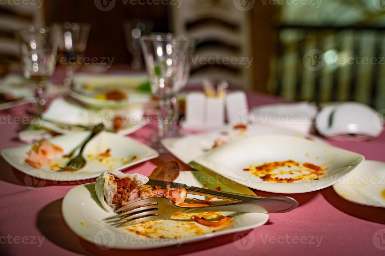 Dishes and glasses are dirty on the table after eating. Empty plates with remnants of food after diner. photo