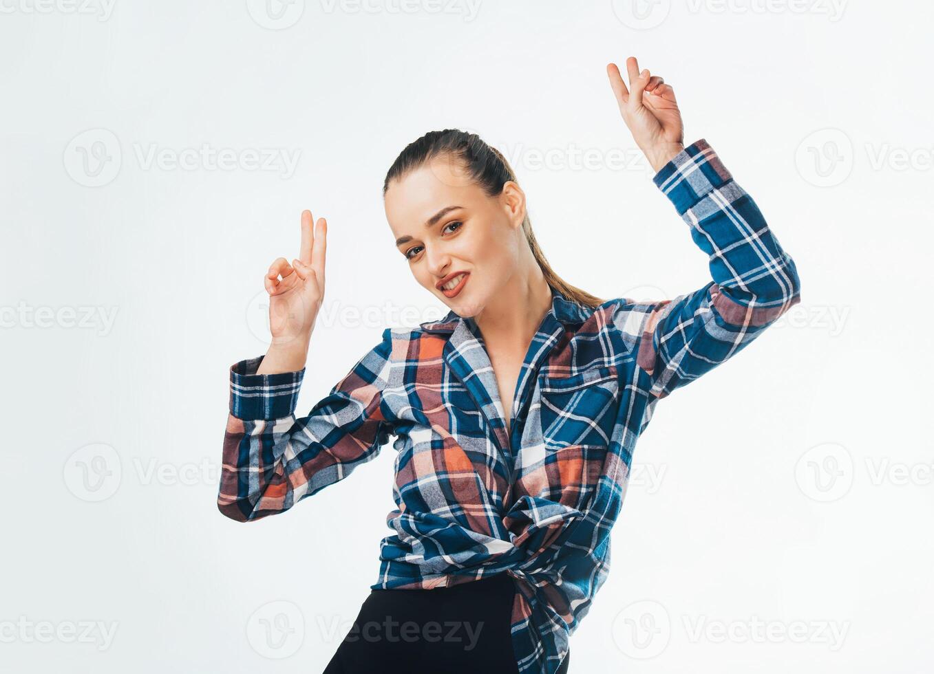 Excited pretty woman pointing fingers up with successful idea. Portrait of a happy cheerful girl showing peace gesture with two hands isolated over white background. photo