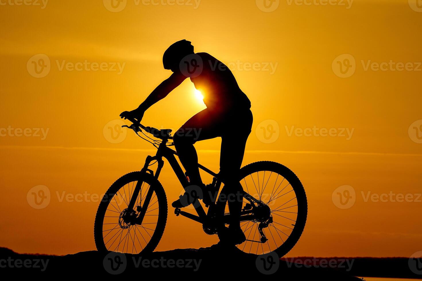 Silhouette Young man of cycling on sunset background. Bicycle and ecology lifestyle concept photo