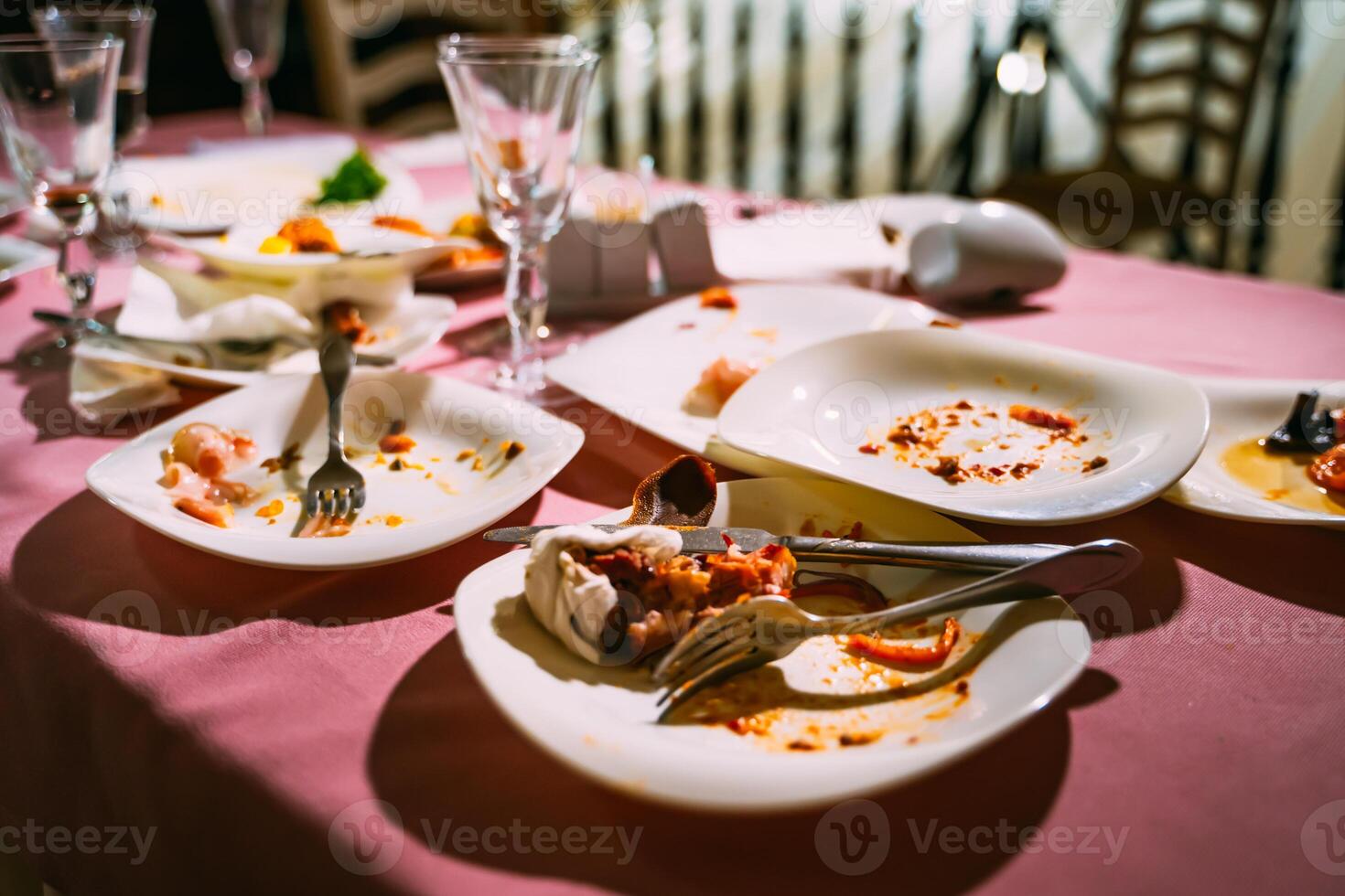Messy table after party. Leftover food, spilled drinks, dirty dishes photo