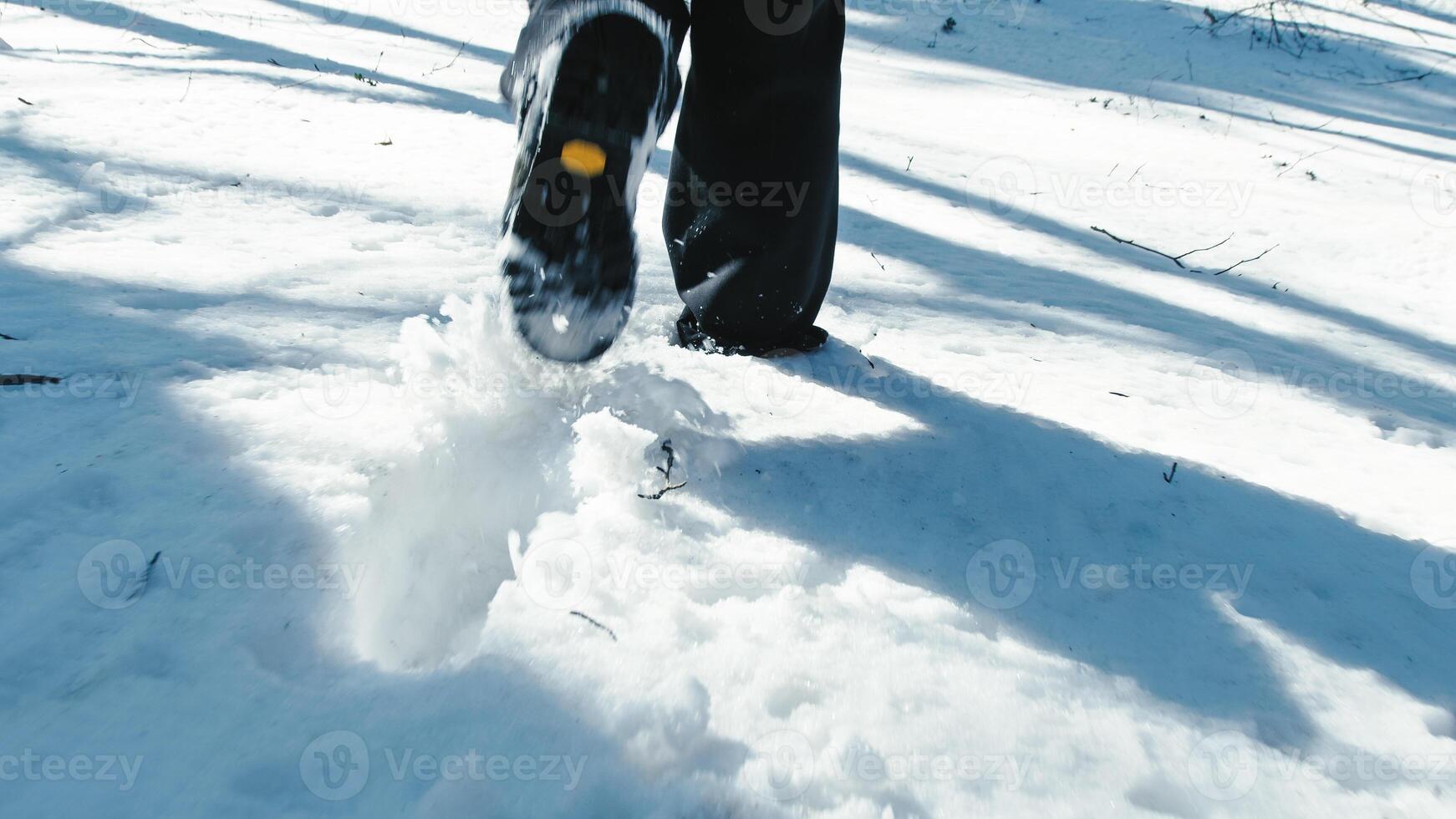 persona despacio caminando en el nieve con botas dejando huellas foto