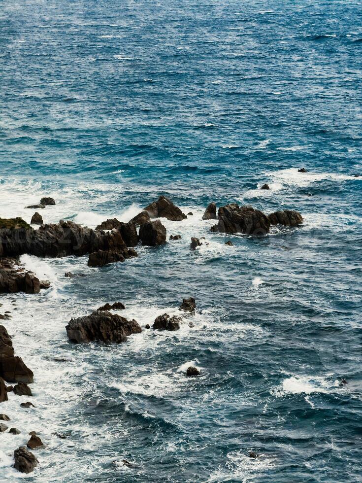 Rocks on ocean water in Calabria photo