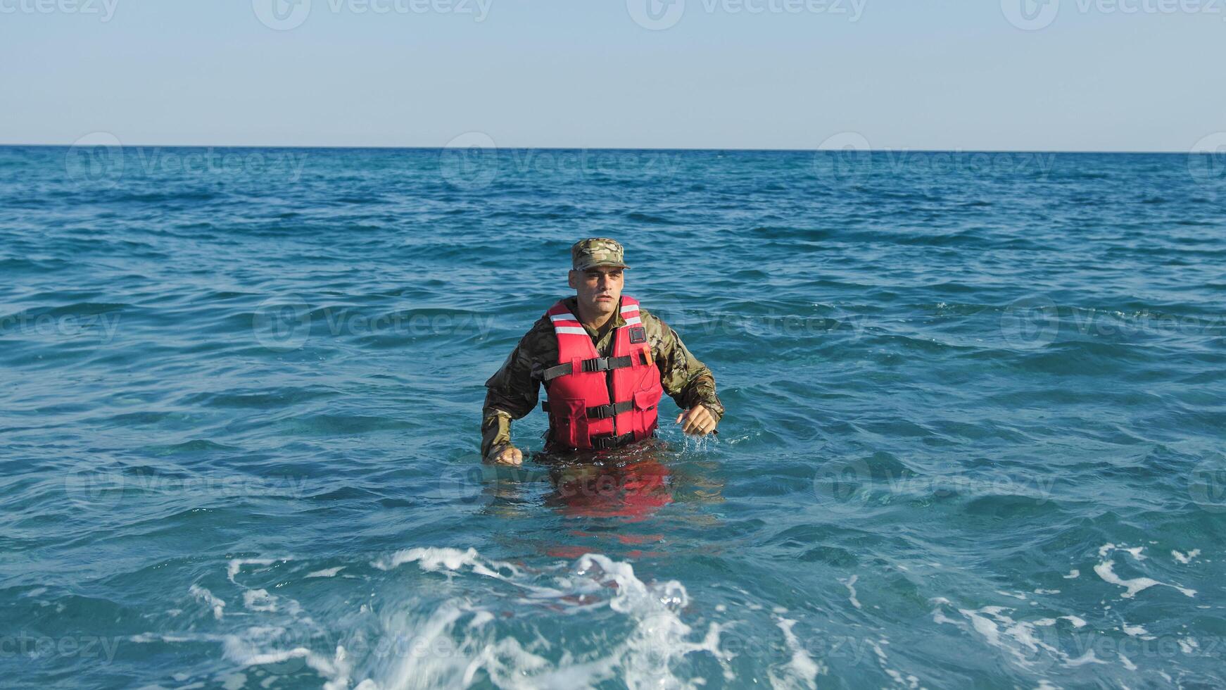 Soldier with life jacket comes out of the sea photo