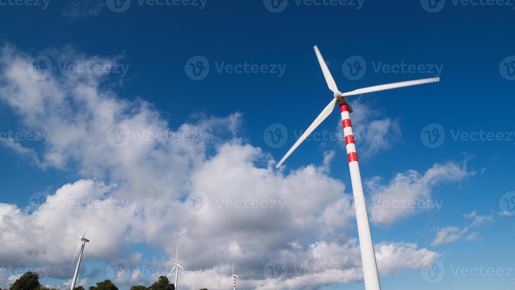 Suggestive natural landscape with white clouds and wind turbines photo