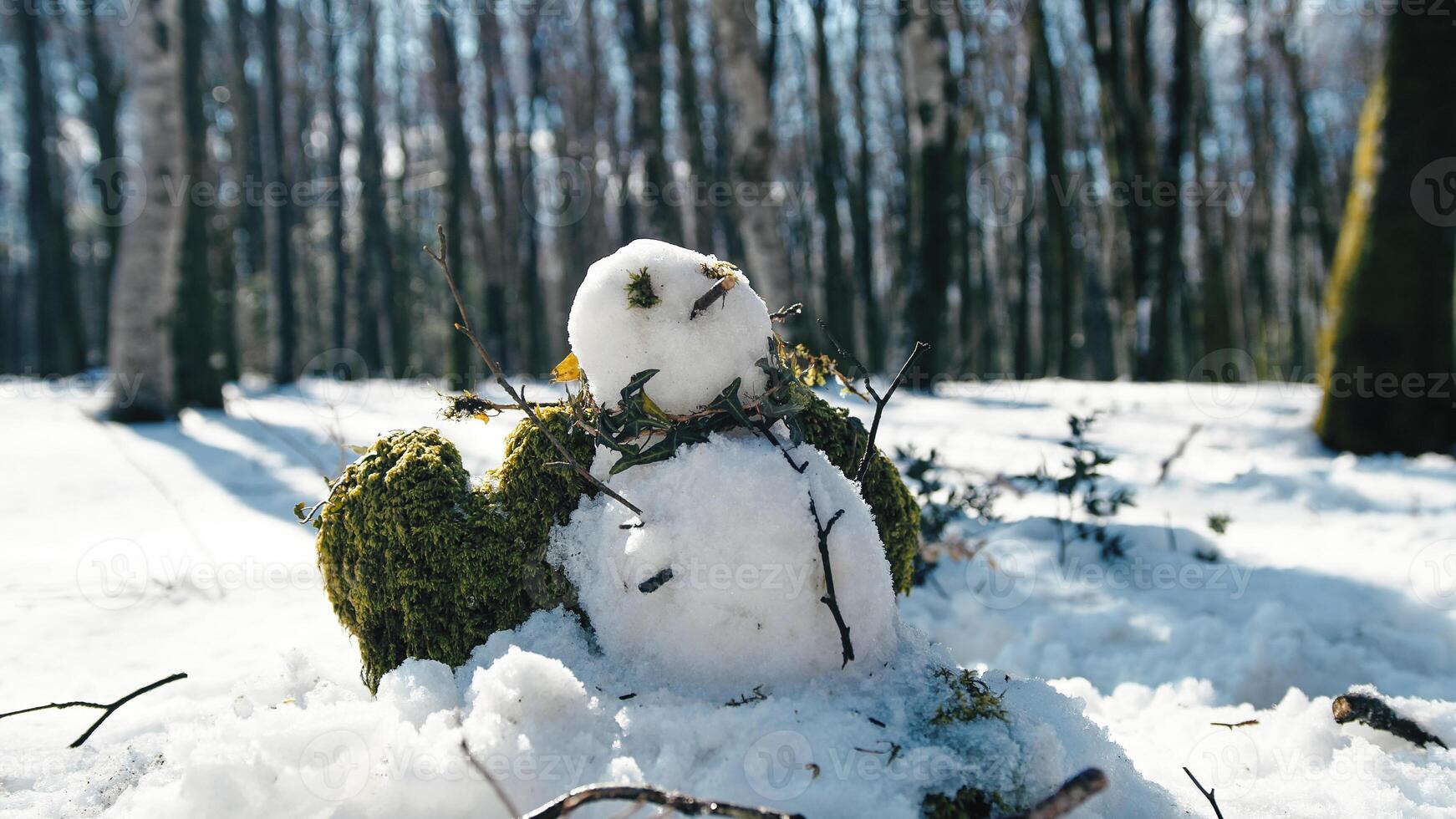 Snowman in the snowy mountain under the sun photo