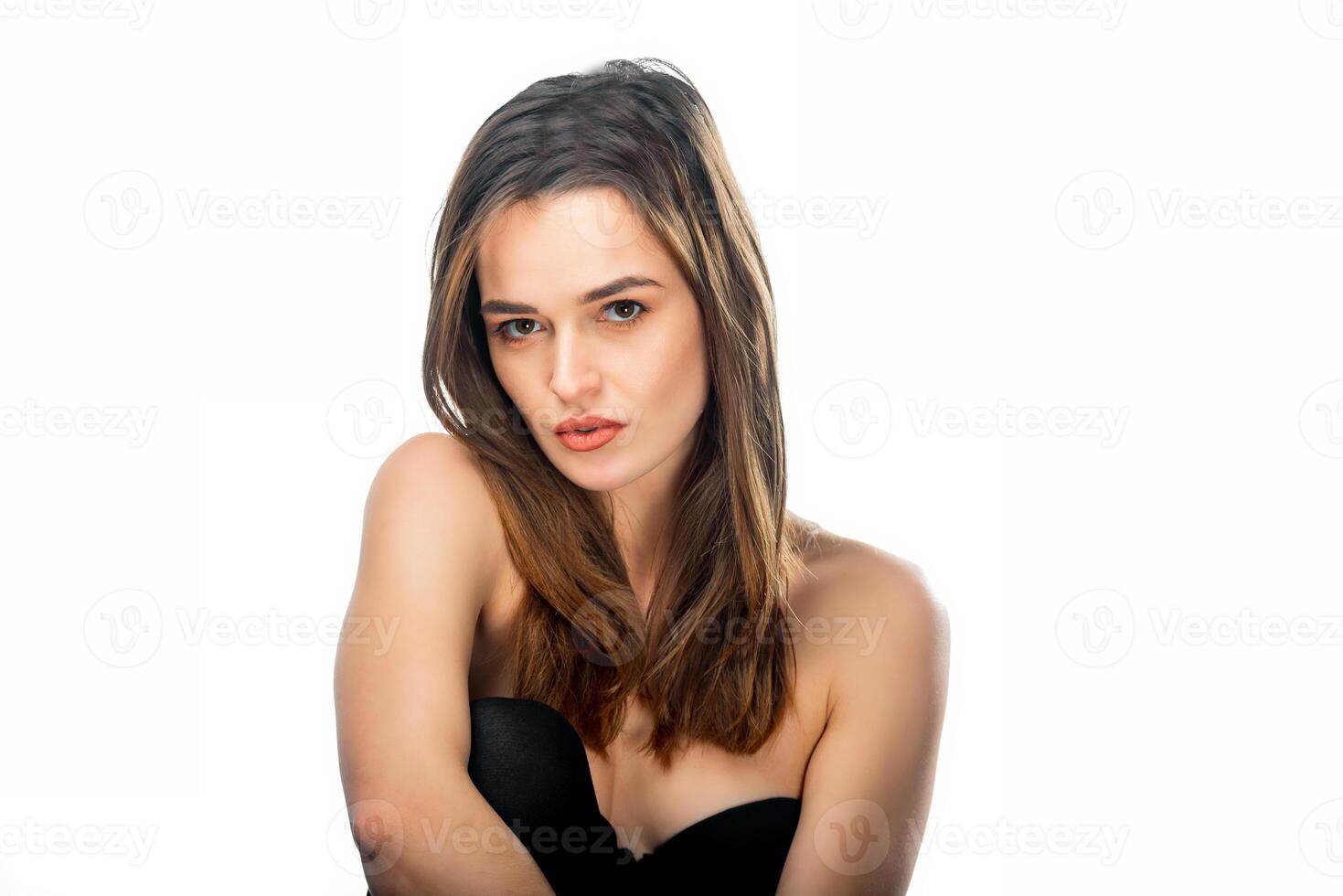 Portrait of a beautiful woman in black underwear looking at camera on a white background. Attractive and sexy model wearing black lingerie. photo