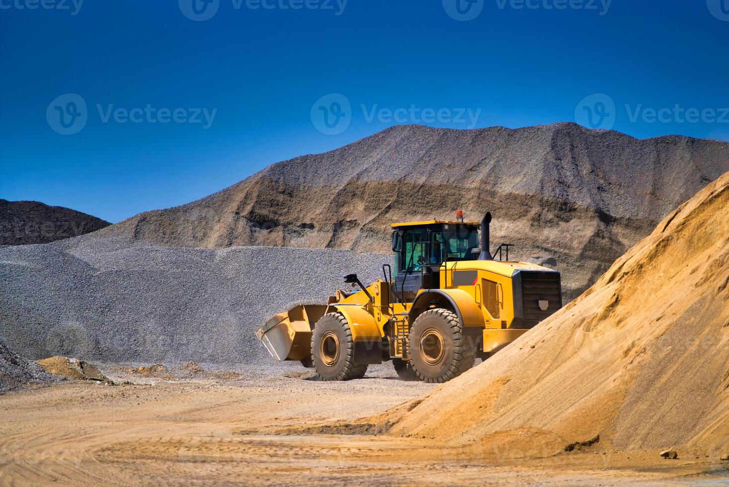 Maintenance of yellow excavator on a construction site against blue sky. repearing wheel loader at sandpit during earthmoving works photo