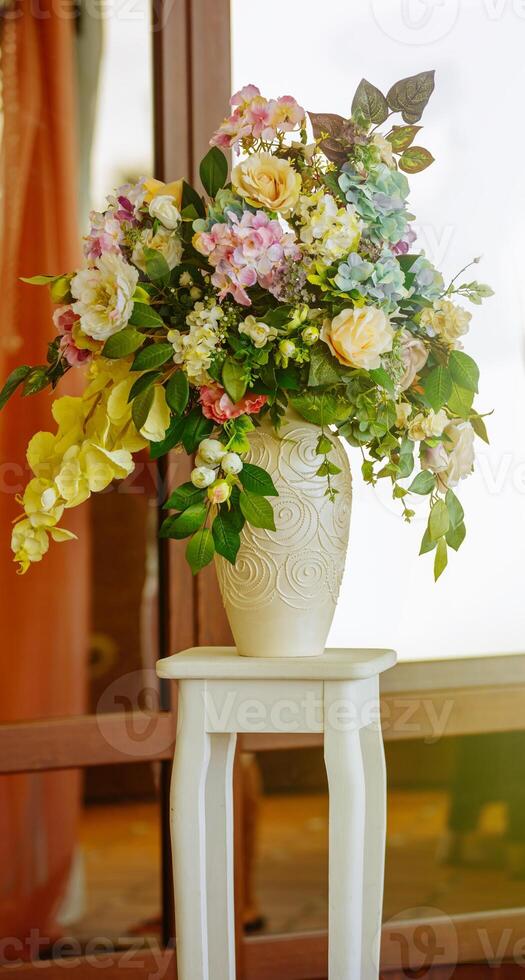 Decoration flowers in a vase on a stand photo