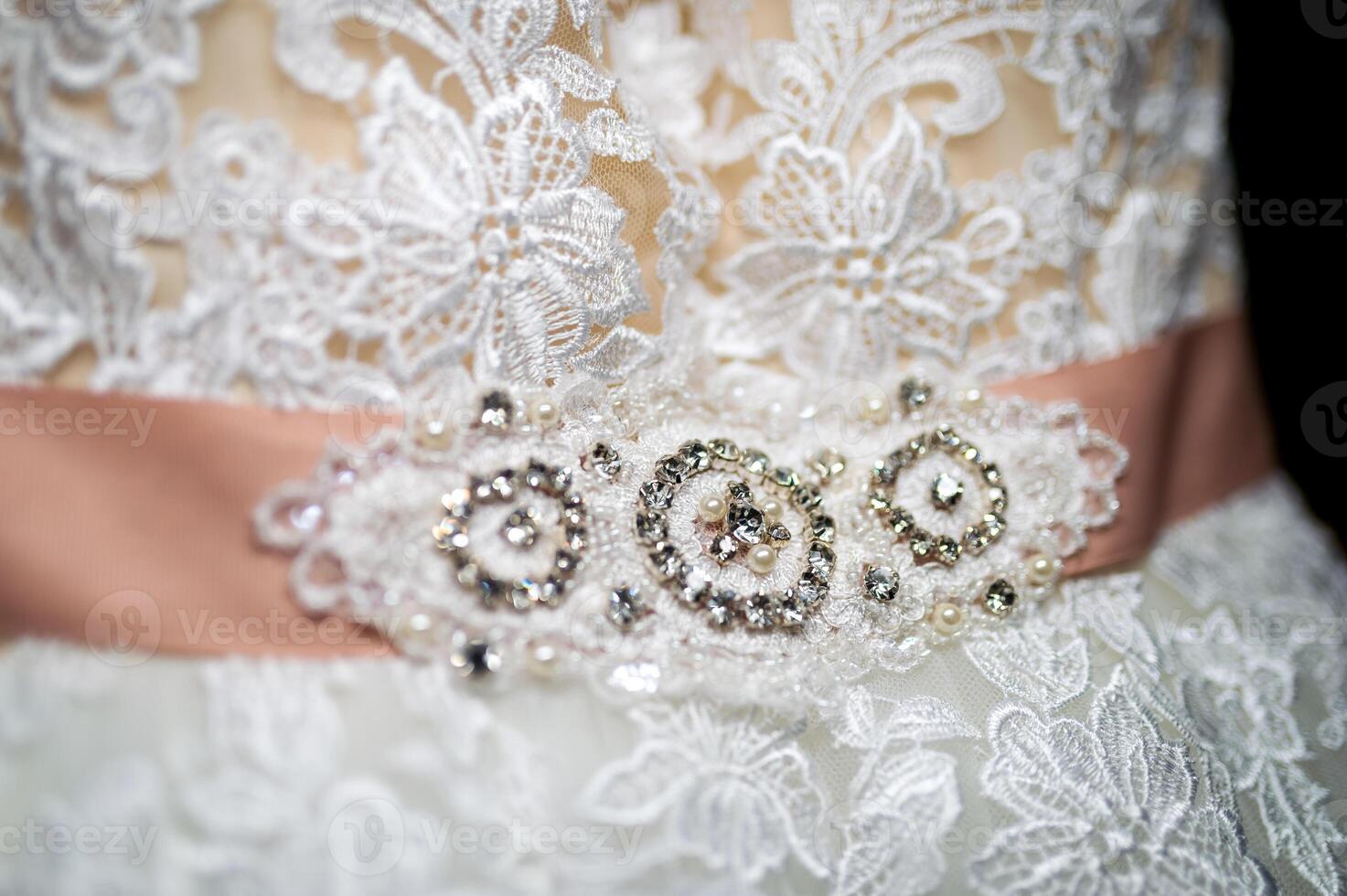 Fragment of a wedding dress with a belt decorated with precious stones and pearls. Bride's dress. Wedding concept photo