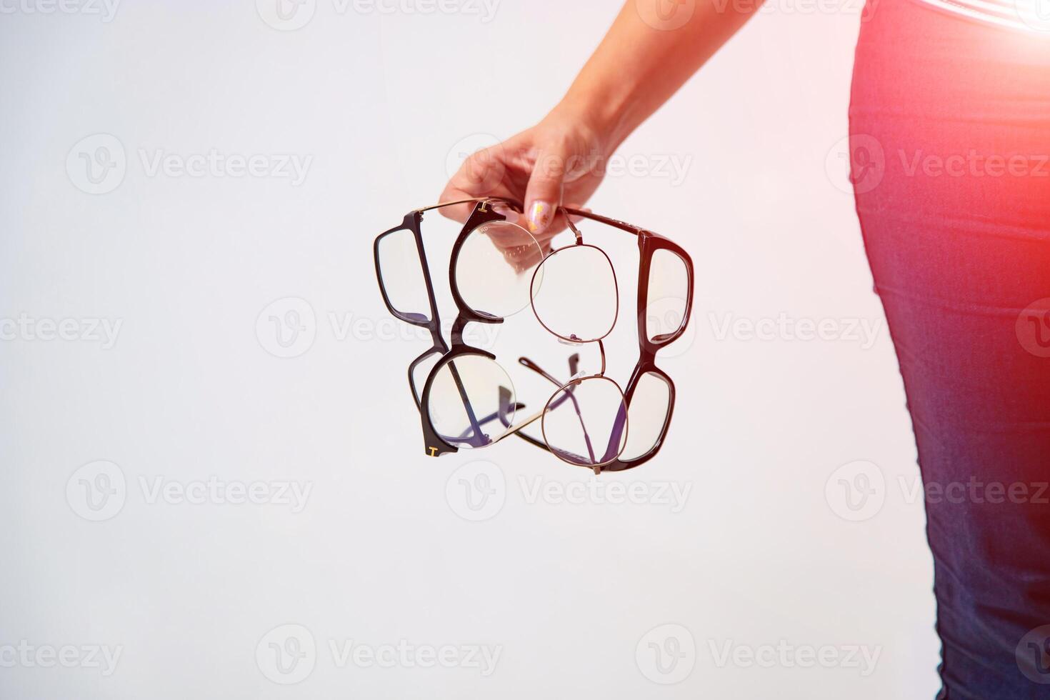 gafas de cerca. mujer mano sostiene negro enmarcado los anteojos. cuatro pares de moderno lentes. foto