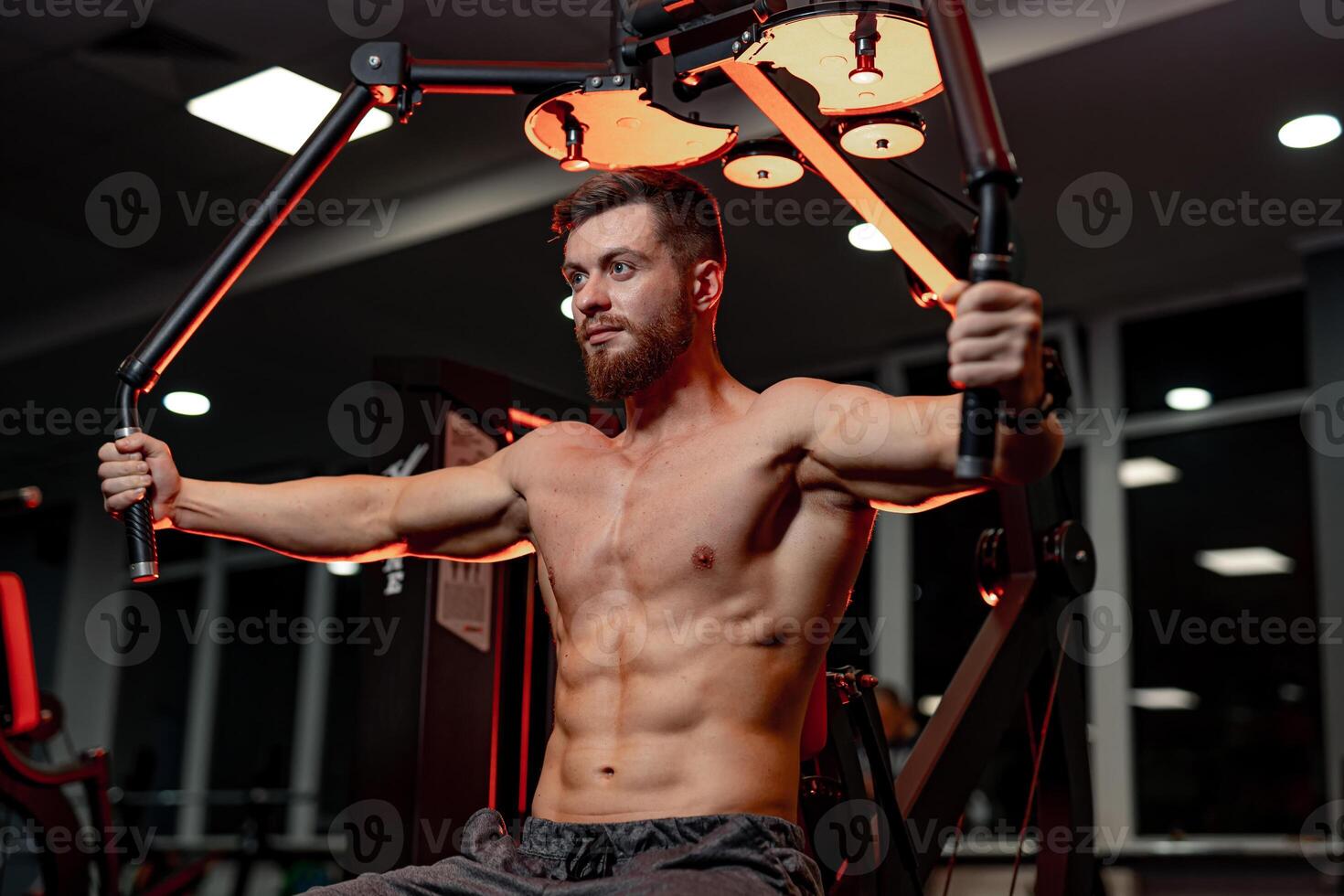 Fitness muscular man training in the gym. Bodybuilder working hard. Handsome young man with sportive muscules powerfull training. photo