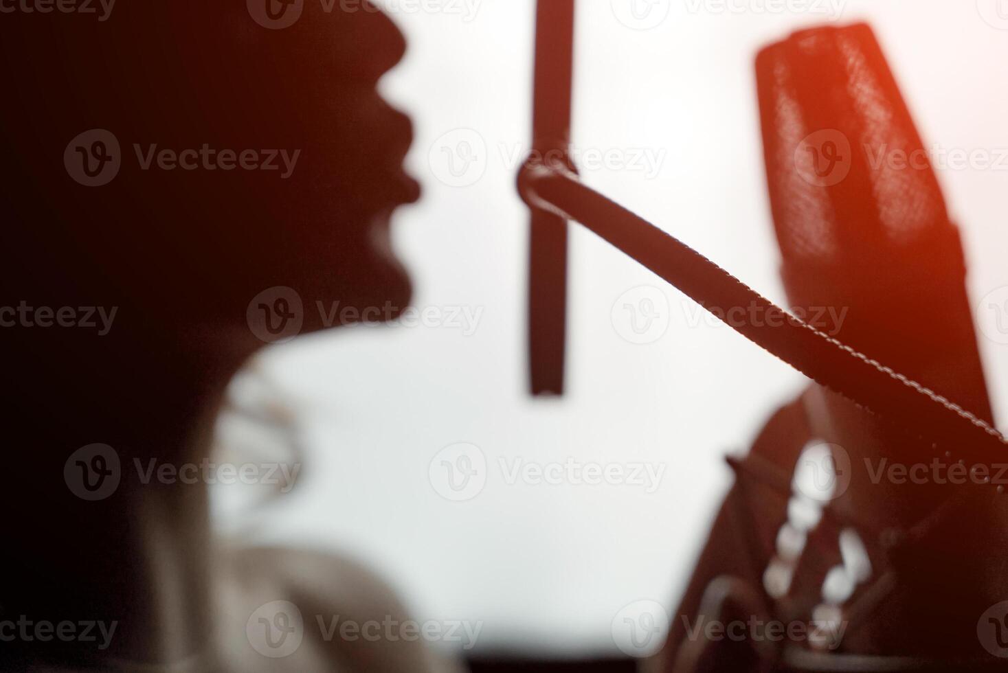 Sexy silhouette female profile with pretty face and bare shoulder near microphone on studio background. Side view portrait of woman singing to microphone. Close-up photo