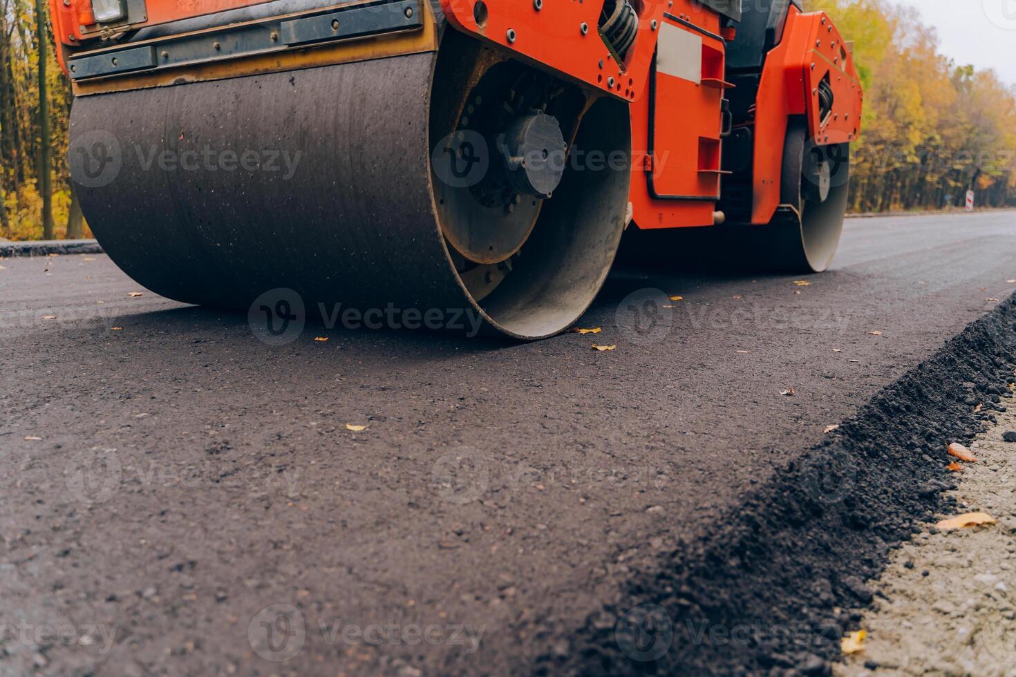 Workers operating asphalt paver machine during road construction. Close view on the road roller working on the new road construction site. photo