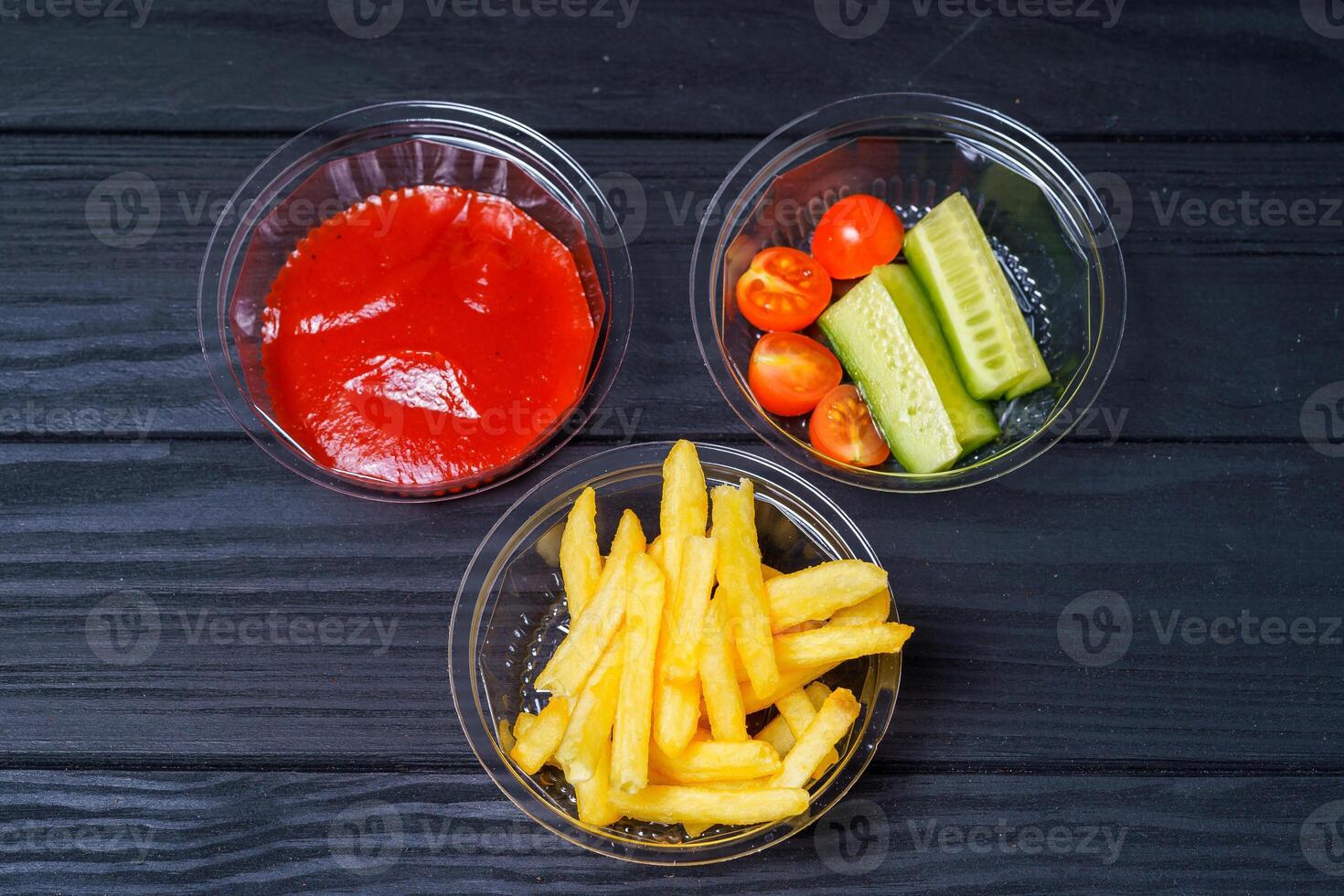 French fries with ketchup and vegetables on dark background. Fast food. Delivery service photo