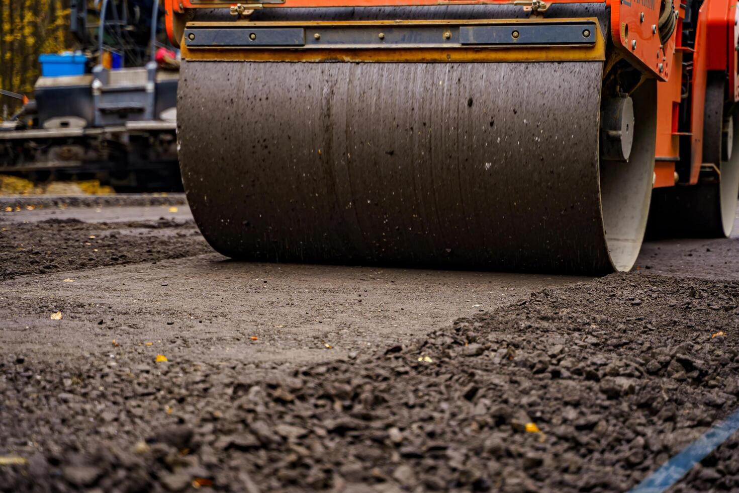 Road repair, compactor lays asphalt. Heavy special machines. Asphalt paver in operation. Side view. Closeup. photo