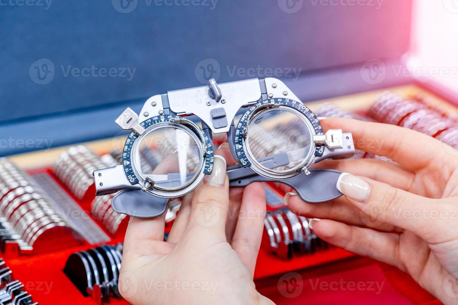 Close-up of ophthalmological trial frame and test glasses in woman's hands. Eysight correction. Young girl is holding corrective spectacles. photo