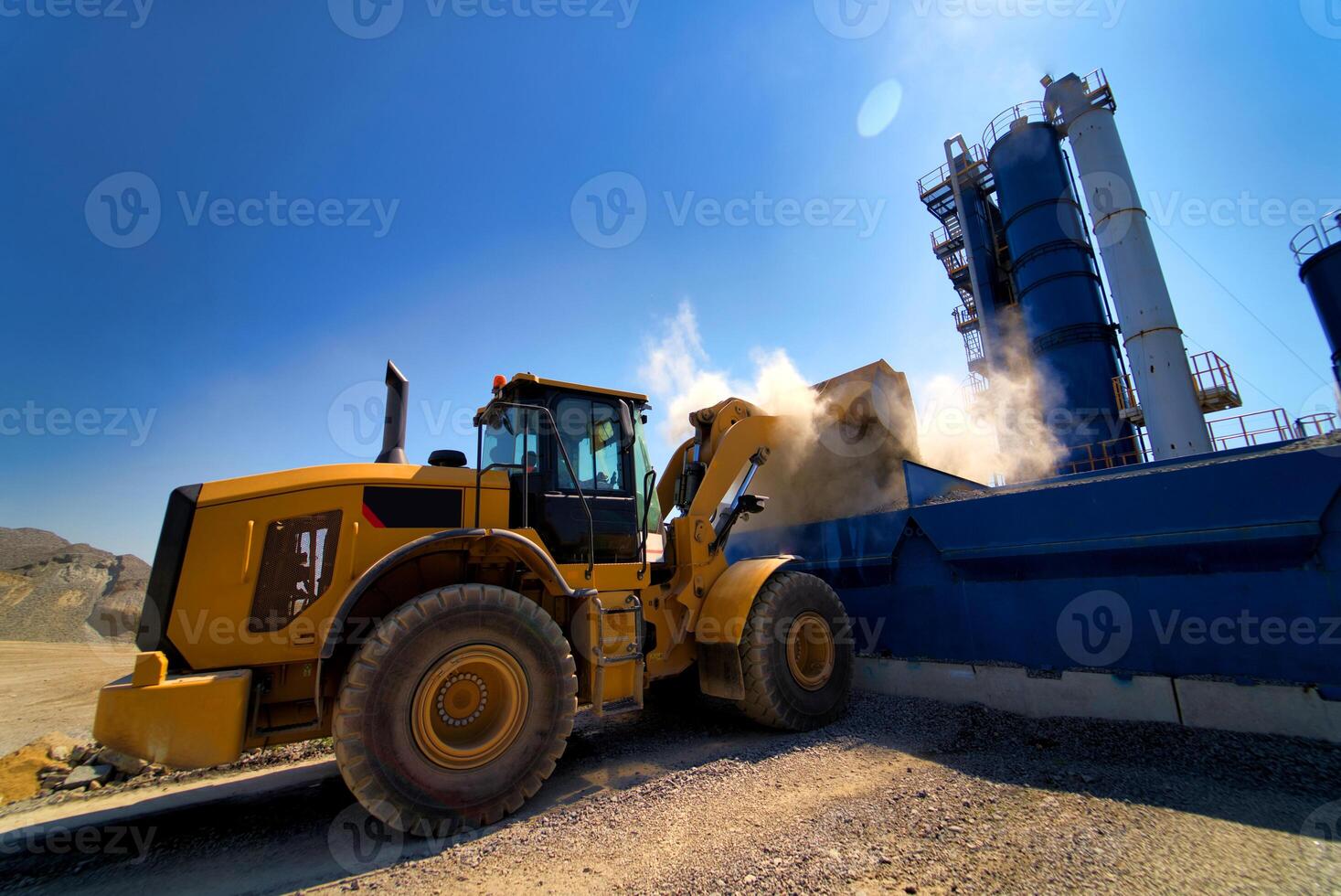 Large tracked excavator on a construction site. Road repair, asphalt replacement. Loading of stone and rubble for its processing at a concrete factory. photo