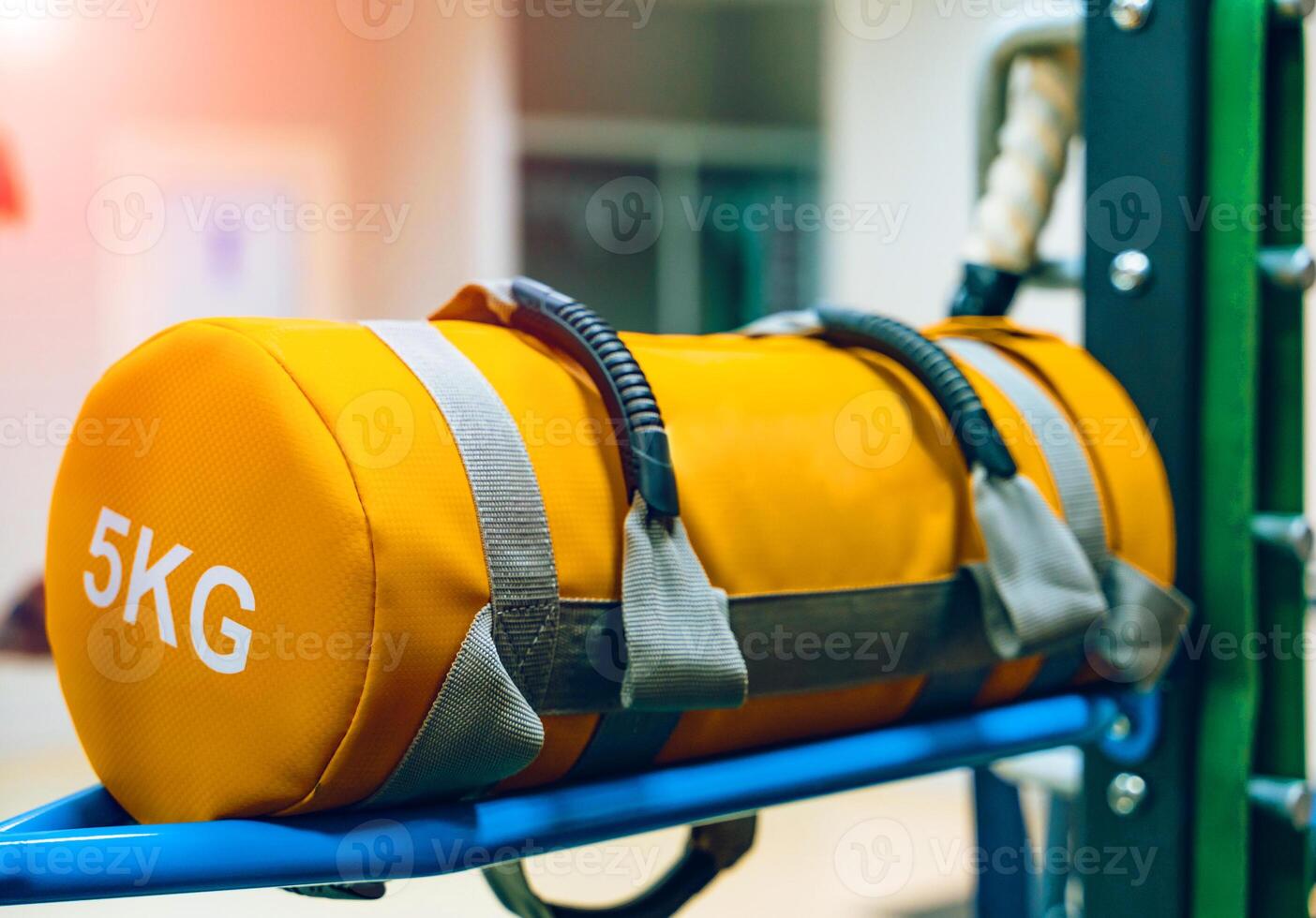 Yellow punching bag of five kilograms on a stand in a gym. Training equipment for sport. Close-up photo