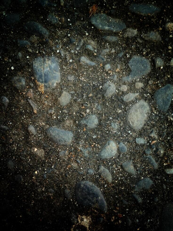 A collection of rocks scattered on the ground, varying in size, shape, color, and texture. photo
