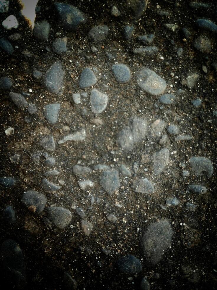 A collection of rocks scattered on the ground, varying in size, shape, color, and texture. photo