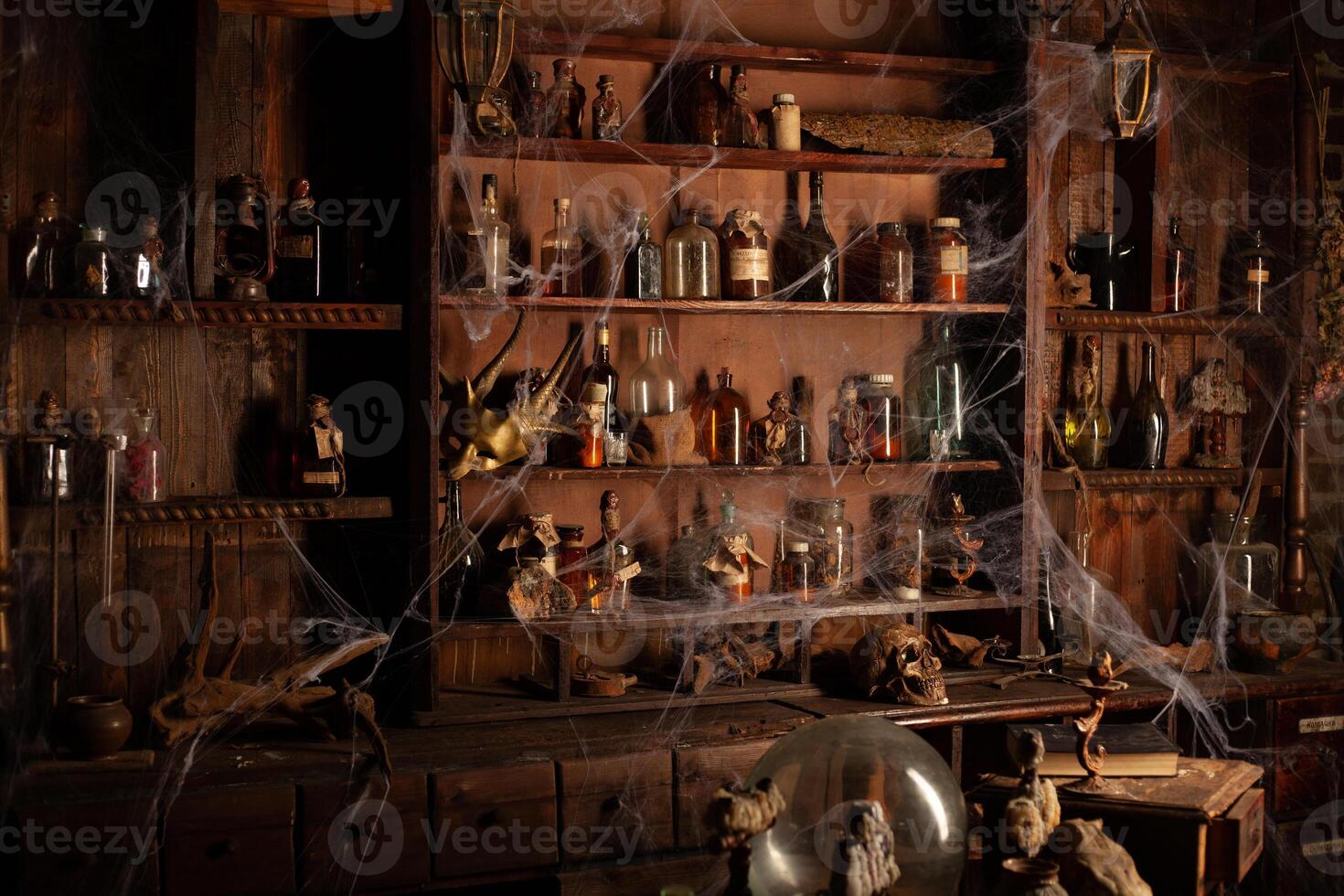 Halloween background Shelves with alchemy tools Skull spiderweb bottle with poison candles photo