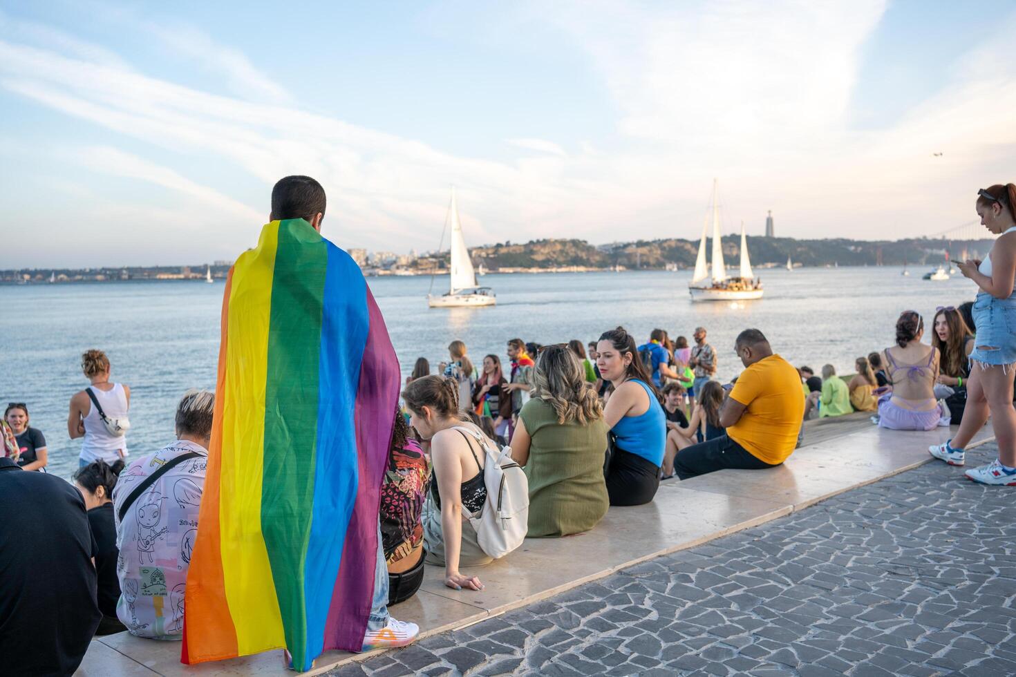 Portugal, Lisbon, June 2023. Group of people with rainbow flags at Pride Parade photo